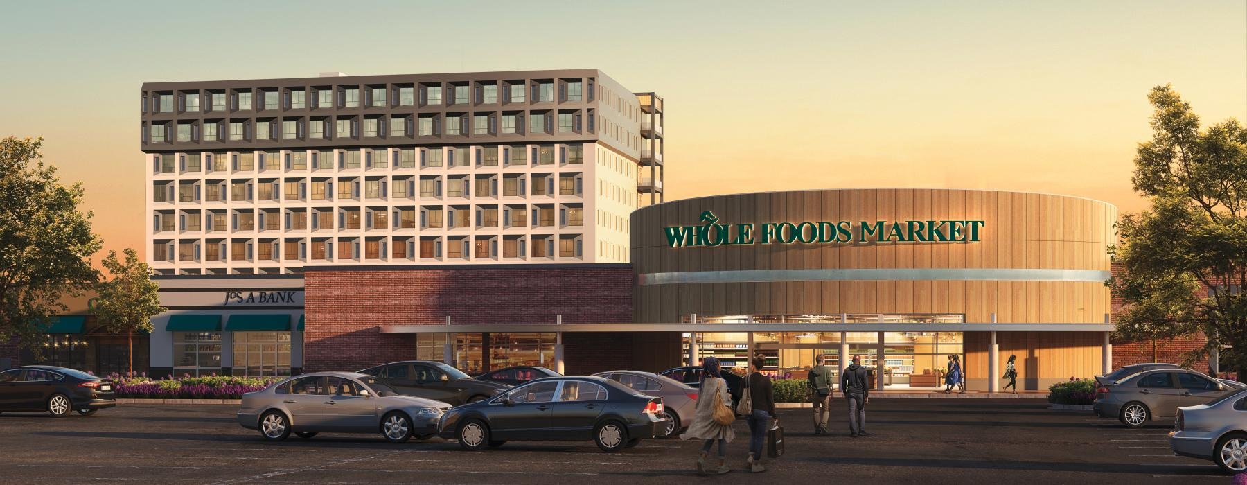 a parking lot with cars and people near a Whole Foods grocery