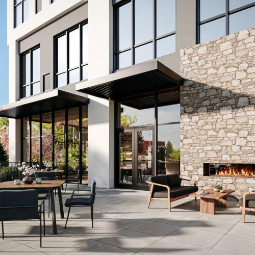 a patio with a table and chairs outside a building and a fireplace